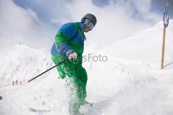 Молодой человек катается на горных лыжах
