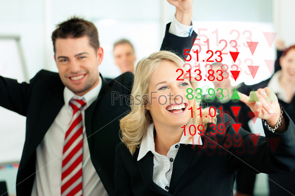 Business - presentation within a team; a female banker or consultant shows figures or share prices on screen