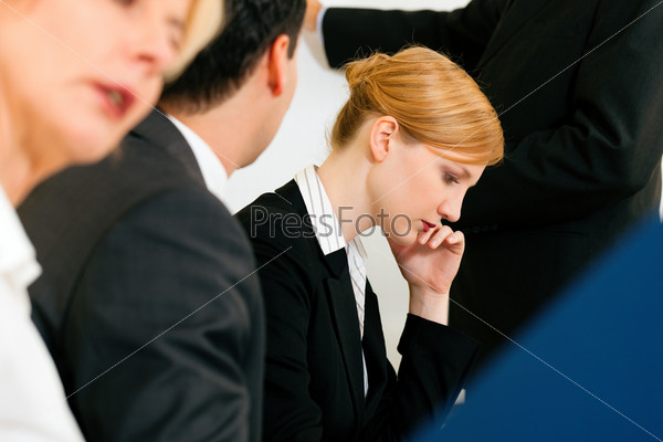Business team receiving a presentation held by a male co-worker standing in front of a flipchart