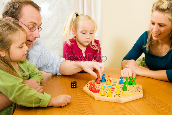 Family playing a board game together having a lot of fun