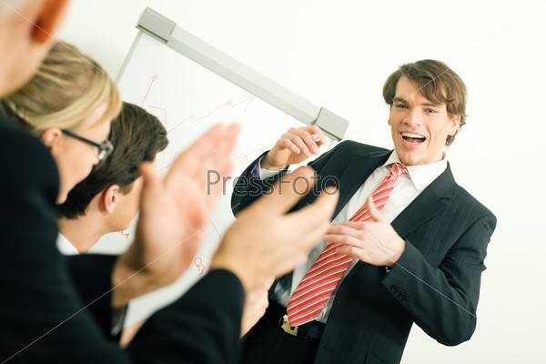 Business team applauding after a successful business presentation (selective focus only on the presenter!), stock photo