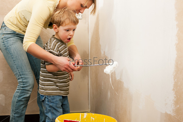 Family - mother with son - painting the wall of their new home or apartment, apparently they just moved in