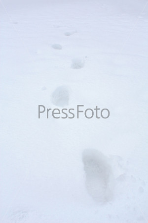 Human footprints in deep snow on sunny day