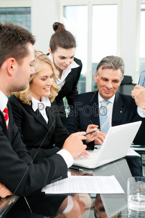 Business - team meeting in an office with laptop, the boss with his employees
