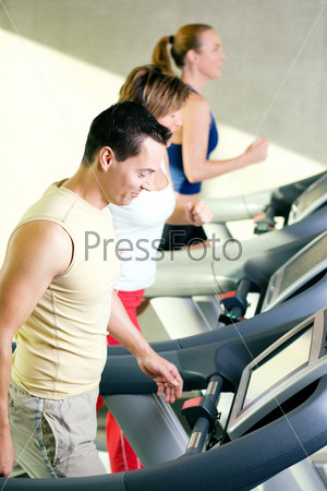 Three people on the treadmill in a gym running