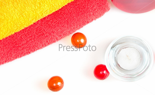 Разноцветные махровые полотенца, свеча и шарики для спа-процедуры