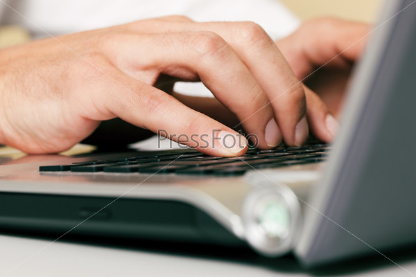 Мужские руки на клавиатуре ноутбука