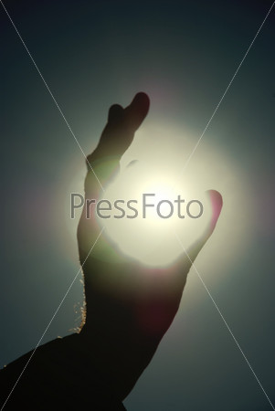 Man holding a sun in his hands against the sky, stock photo