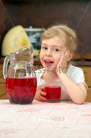 Little funny girl drinking cranberry drink.