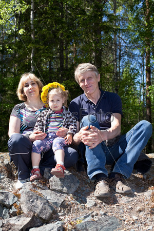 Молодая семья, сидящая на камнях