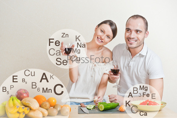 Young lovely couple cooking a balanced diet. Big copyspace. Vitamins and microelements symbols are around them.
