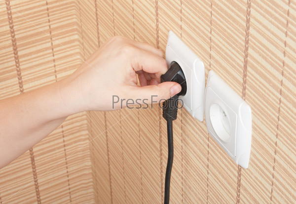 Hand insert the plug into the power, stock photo