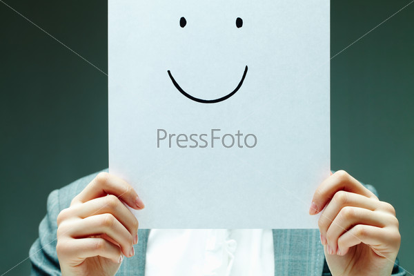Image of female holding paper with drawn smile by her face