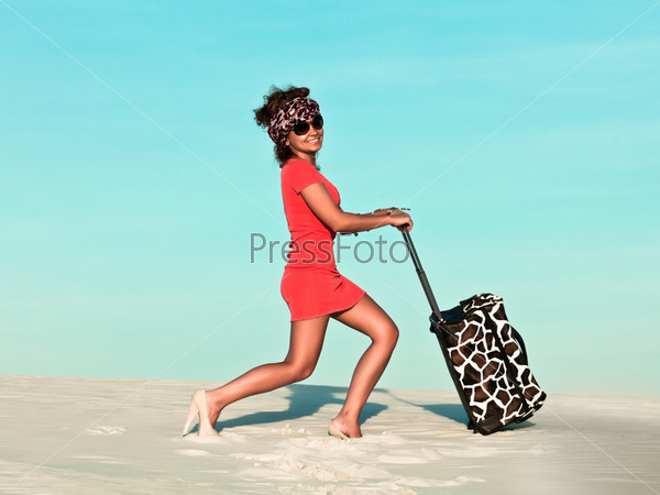Beautiful woman with travel bag in desert