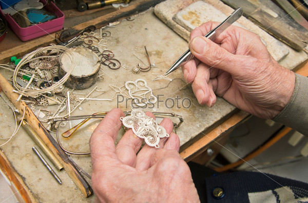 Hands of jeweller at work, stock photo