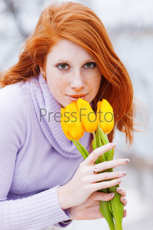 Beautiful woman smelling spring flowers