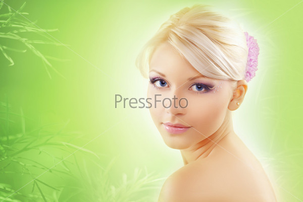 Cheerful young cute woman with clear skin over natural green background, stock photo