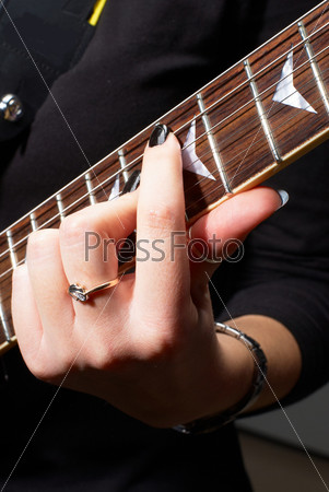 Woman playing on guitar, Closeup view