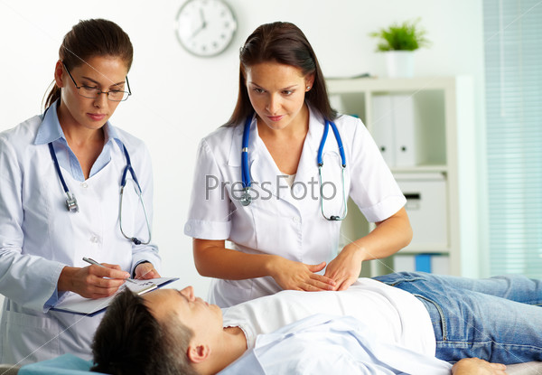 Portrait of confident female doctors during medical treatment of patient in hospital