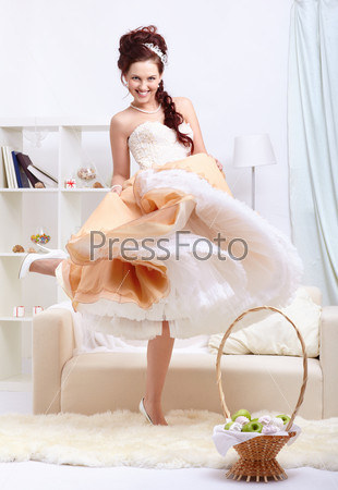 Portrait of young beautiful dancing retro woman in vintage skirt with petticoat and corset on gray
