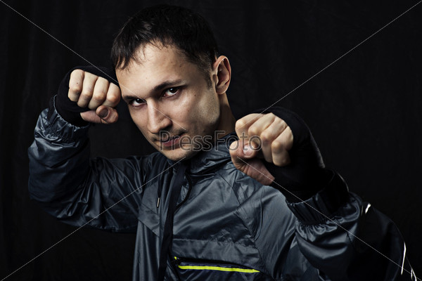 Mixed martial arts. Portrait of Young street fighter on black background