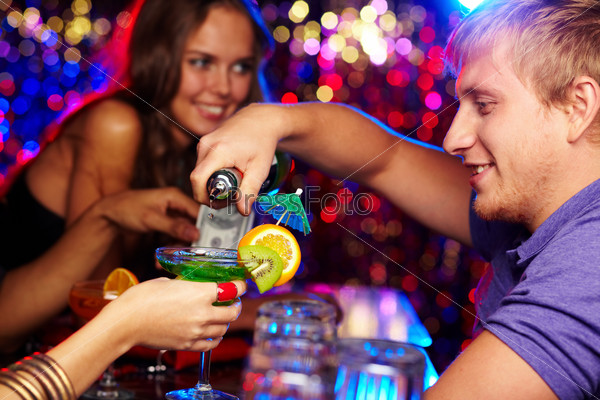 Cheerful bartender pouring cocktails at a birthday party
