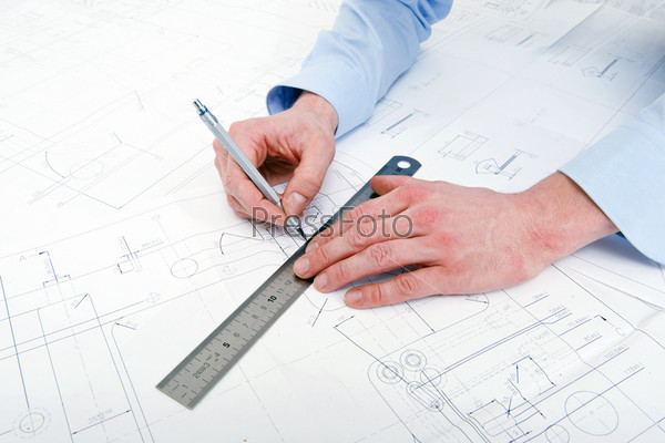 Engineer, drawing a line with a refillable pencil along a steel ruler