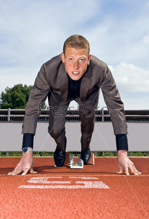 young businessman wearing a suit in the starting blocks to start building his career