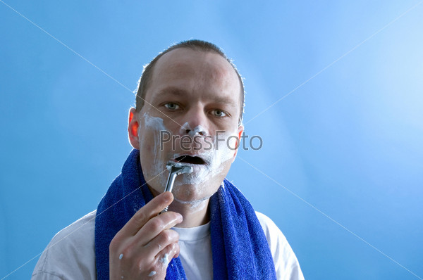 a middle aged man dressed in a white t-shirt, shaving himself
