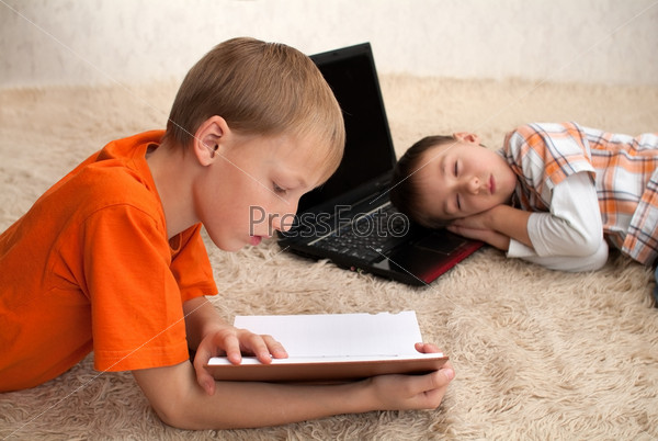 One child read while the other sleeps, stock photo