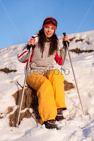 Beautiful young woman in a ski sport suit and mask in the snow