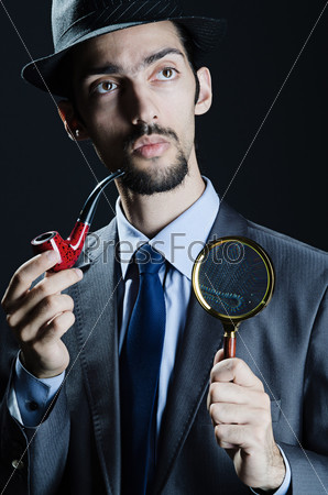 Detective with magnifying glass and pipe, stock photo