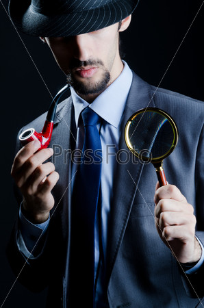 Detective with magnifying glass and pipe, stock photo