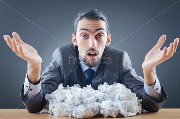 Businessman with lot of discarded paper
