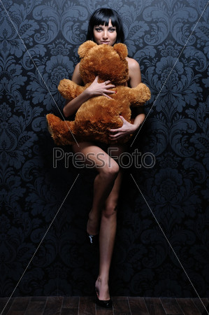 Beautiful naked girl is holding the teddy bea