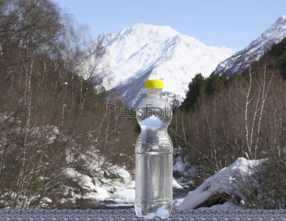 A bottle of pure water against majestic snow top, stock photo