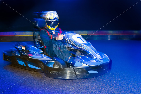 Go-cart driver during a lap on an indoor carting circuit