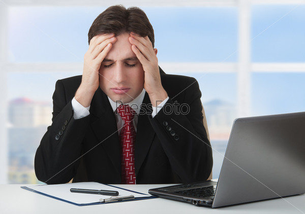young businessman under stress, fatigue and headache, he kept his hands behind his head