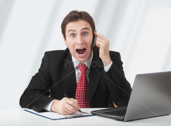 Surprisedbusiness man talking on the phone, experiences fear and surprise, stock photo
