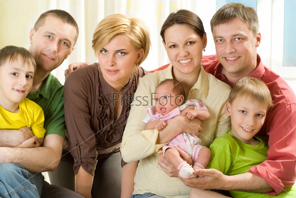 portrait of a happy family of seven people on a light