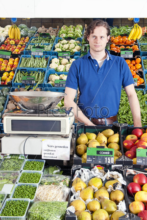 Продавец фруктов и овощей в магазине
