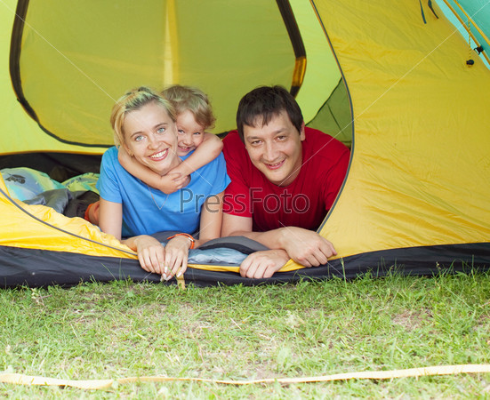 Happy family in the tent. Father, mother and child camping