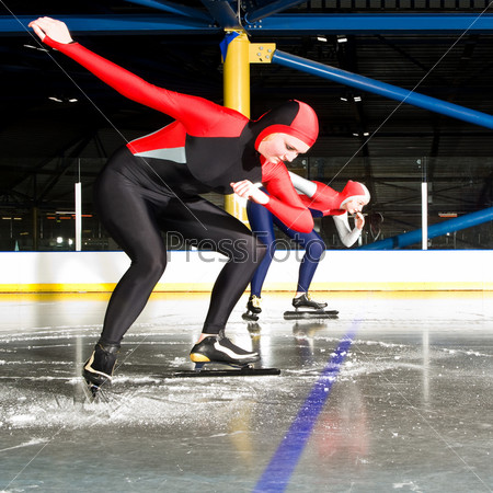 The start of a women speed skating race in an indoor ice rink