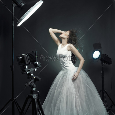 Beautiful young woman in white dress pose in studio