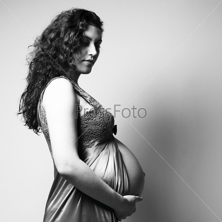 Fine art portrait of young pregnant woman. Studio photo.