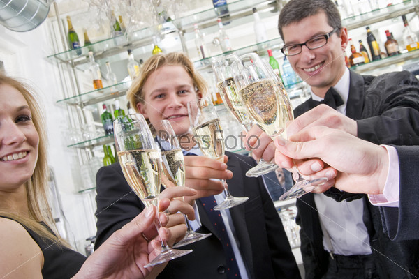 several people toasting with champagne while looking in the camera