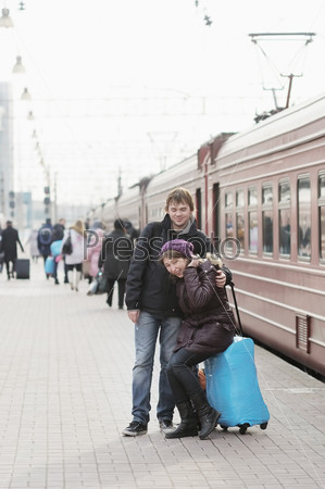Молодая пара ждет поезда на железнодорожной платформе