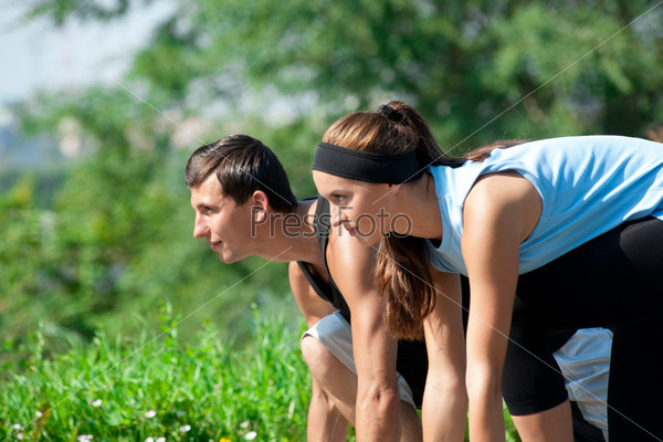 Young fitness couple of man and woman ready to start running