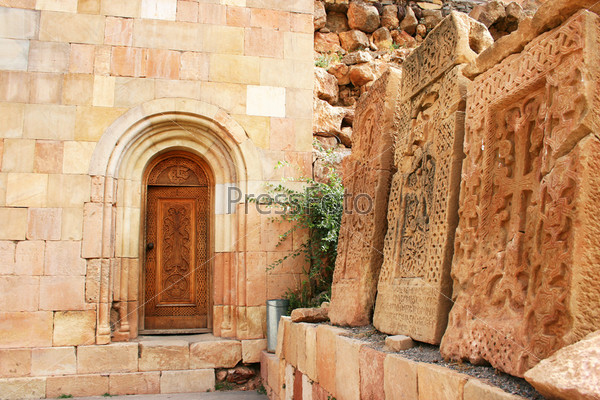 Cross-stones at Noravank monastery in Armenia, red rocky mountains.