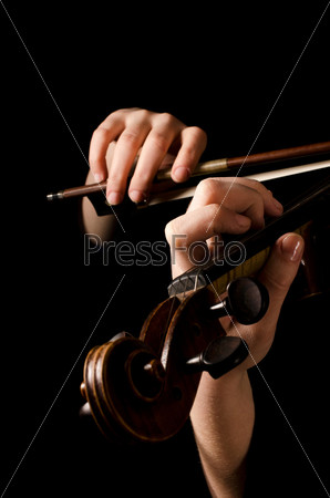 Female hands play a violin on the black